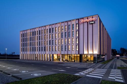 un edificio con un cartel en el costado en Hampton by Hilton Riga Airport, en Riga