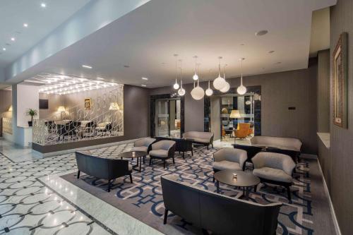 a lobby with a waiting area with chairs and tables at Hilton Podgorica Crna Gora in Podgorica