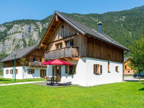 ein großes Holzhaus mit einem Tisch auf einem Feld in der Unterkunft Beautiful Chalet in Obertraun with Garden in Obertraun