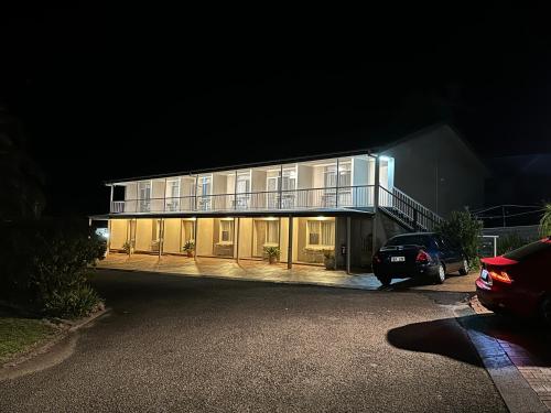 a house at night with a car parked in front of it at Holiday Lodge Motor Inn in Narooma