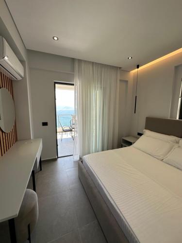 1 dormitorio con cama y vistas al océano en Villa Idrizi, en Sarandë