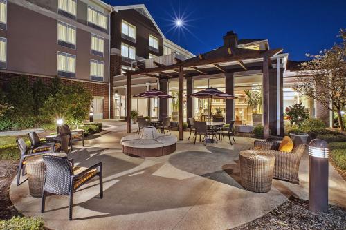 een patio met stoelen, tafels en parasols bij Hilton Garden Inn Akron-Canton Airport in North Canton