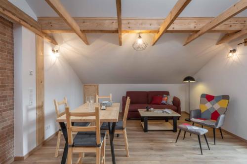 - un salon avec une table, des chaises et un canapé dans l'établissement Ski-Bike-Apartment Bayerwald, à Lohberg