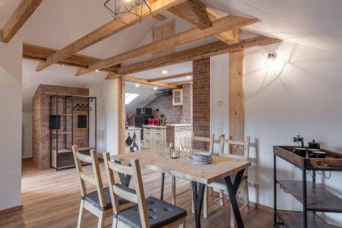 Il comprend une cuisine et une salle à manger avec une table et des chaises en bois. dans l'établissement Ski-Bike-Apartment Bayerwald, à Lohberg