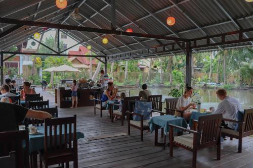 un groupe de personnes assises à table dans un restaurant dans l'établissement Villa Oasis, à Luang Prabang