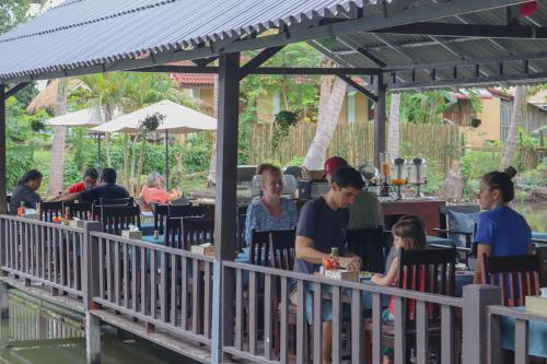 un groupe de personnes assises dans un restaurant en plein air dans l'établissement Villa Oasis, à Luang Prabang