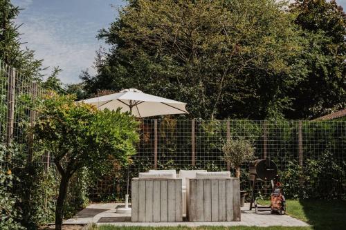 a patio with an umbrella next to a fence at Life & Cooking Holiday Home in Ermelo