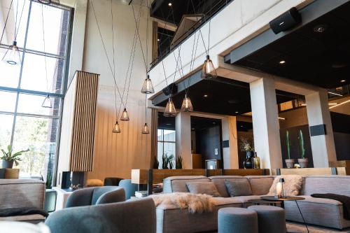 eine Lobby mit Sofas und Stühlen in einem Gebäude in der Unterkunft Hotel Rosveld in Nederweert