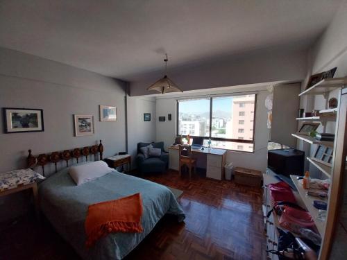 a bedroom with a bed and a desk and a window at Habitaciones Frente Club Tenis in Cochabamba