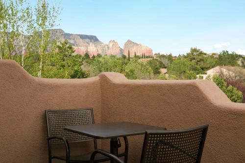 een kleine tafel en stoelen op een balkon met uitzicht op de bergen bij Hampton Inn Sedona in Sedona