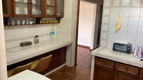 a kitchen with a counter and a microwave in it at Habitaciones Frente Club Tenis in Cochabamba