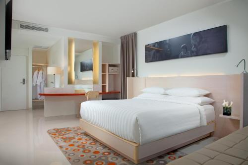 Cet appartement comprend une chambre avec un lit blanc et une cuisine. dans l'établissement Fairfield by Marriott Surabaya, à Surabaya