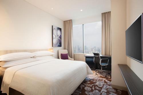 Habitación de hotel con cama, escritorio y ventana en Four Points by Sheraton Jakarta Thamrin en Yakarta