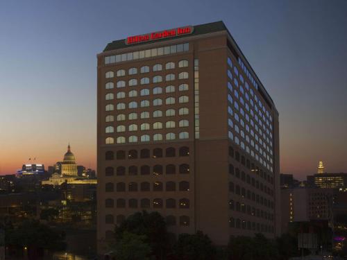 Un grand bâtiment avec un panneau en haut dans l'établissement Hilton Garden Inn Austin Downtown-Convention Center, à Austin