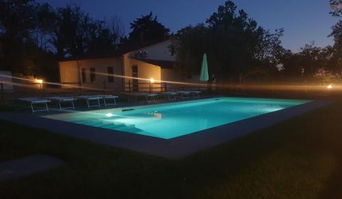 uma piscina com cadeiras e uma casa à noite em Il Sottolo em Florença