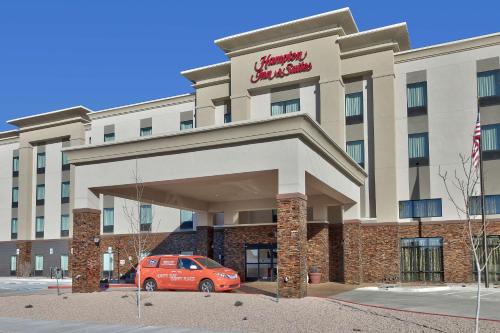 アルバカーキにあるHampton Inn & Suites Albuquerque Airportのホテルの正面に車を停めています