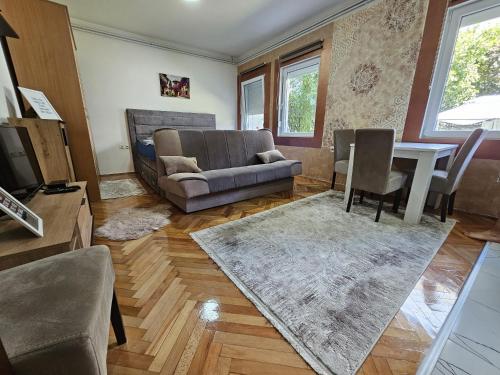 uma sala de estar com um sofá e uma mesa em ALOHA apartment em Novi Pazar