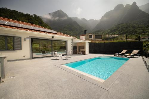 - une piscine en face d'une maison avec des montagnes dans l'établissement Casa Avô da Pedra, By OP, à São Vicente