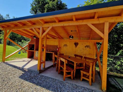 einem Holzpavillon mit einem Holztisch und Stühlen in der Unterkunft Casa Emmara Sighisoara in Sighişoara