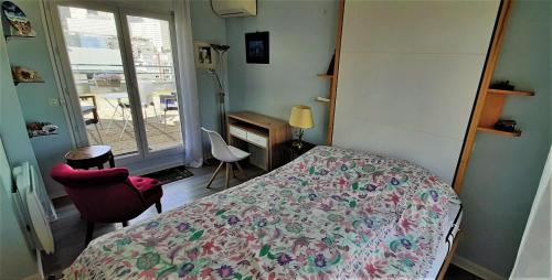 una camera con letto, scrivania e finestra di Appartement avec Terrasse à Puteaux 92 a Puteaux