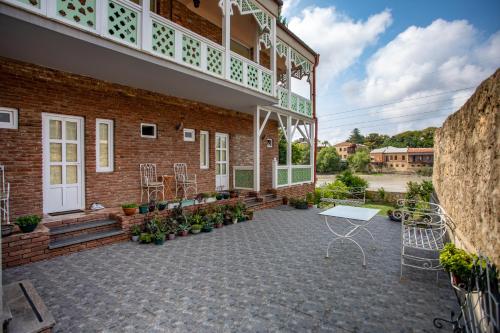 a patio outside of a building with a table and chairs at Hotel Paradise Road in Kutaisi