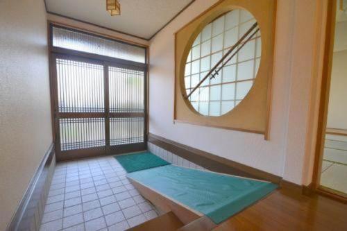 Zimmer mit einem großen Fenster und einem Spiegel in der Unterkunft Wholeearth Ryokan Hiroshima in Hiroshima