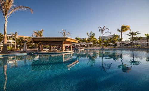 una grande piscina con un edificio e palme di Grand Bliss Nuevo Vallarta a Nuevo Vallarta