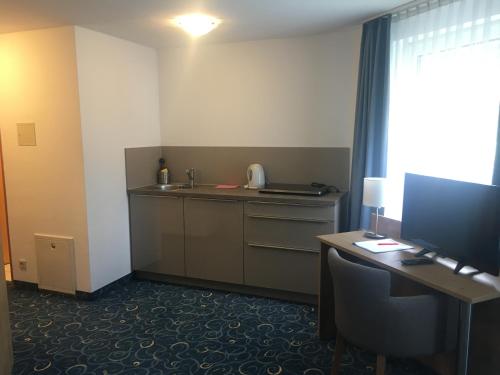 un ufficio con scrivania, computer e monitor di Appartis - Hotel am Stadtpark a Sindelfingen