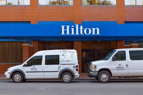 zwei weiße Vans, die vor einem Laden geparkt sind in der Unterkunft Hilton Fort Wayne at the Grand Wayne Convention Center in Fort Wayne