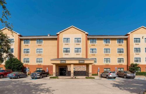 un grande edificio con auto parcheggiate in un parcheggio di Extended Stay America Suites - New Orleans - Metairie a Metairie