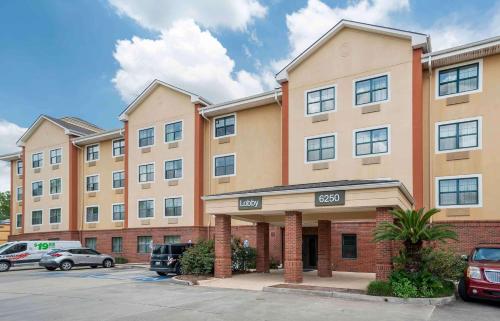 un grande condominio con auto parcheggiate in un parcheggio di Extended Stay America Select Suites - Baton Rouge - Citiplace a Baton Rouge