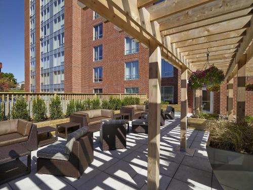 eine hölzerne Pergola mit Stühlen und Tischen vor einem Gebäude in der Unterkunft Hampton Inn by Hilton Halifax Downtown in Halifax