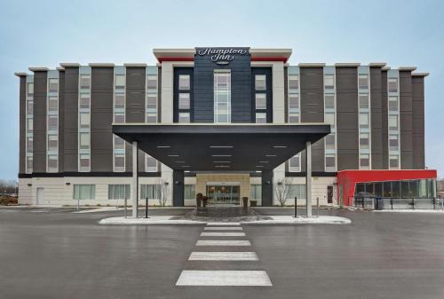 un grand bâtiment avec un panneau en haut dans l'établissement Hampton Inn Peterborough, à Peterborough