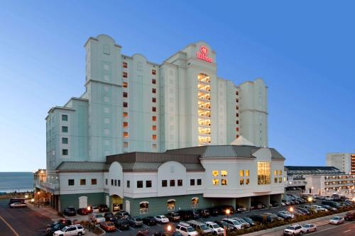 um grande edifício com carros estacionados num parque de estacionamento em Hilton Suites Ocean City Oceanfront em Ocean City