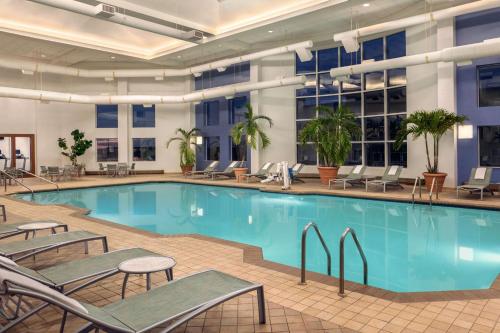 uma piscina num hotel com cadeiras e plantas em Hilton Suites Ocean City Oceanfront em Ocean City