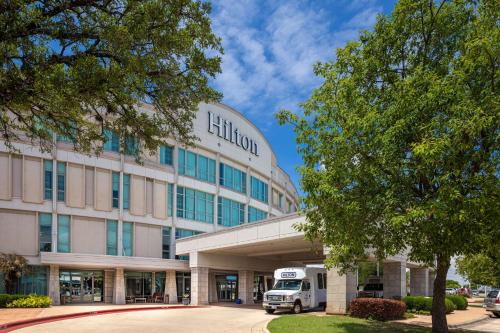 een gebouw met een vrachtwagen voor het gebouw bij Hilton Austin Airport in Austin