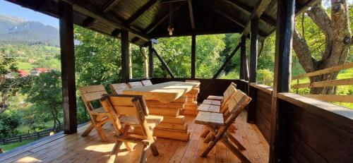 um alpendre com uma mesa e cadeiras num deque em Chalet Poarta em Bran