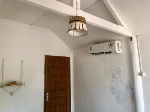 une chambre avec une lampe suspendue au plafond dans l'établissement Easy Bungalow, à Gili Trawangan