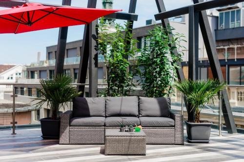 een bank op een balkon met een parasol bij Ramada by Wyndham Budapest City Center in Boedapest