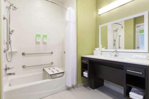 a bathroom with a tub and a sink and a mirror at Home2 Suites by Hilton Amarillo West Medical Center in Amarillo