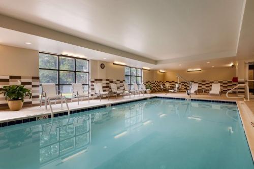 uma piscina num hotel com cadeiras e mesas em Hampton Inn and Suites Camp Springs em Camp Springs