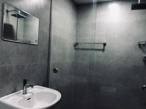 bagno con lavandino e doccia in vetro di Garuda Suites a Varkala