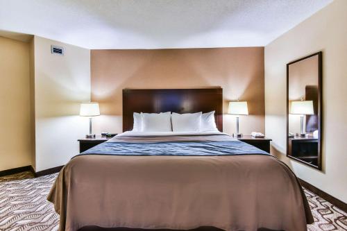 a bed in a hotel room with two lamps at Comfort Inn & Suites Ambassador Bridge in Windsor