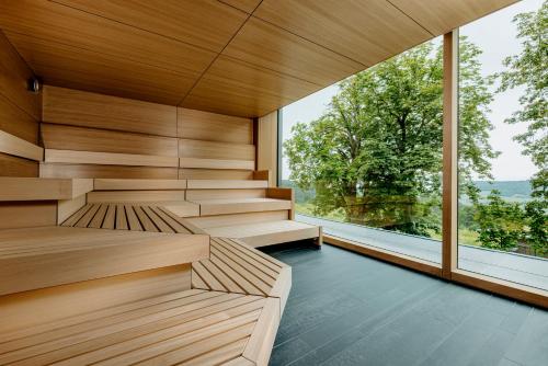 uma sauna com paredes de madeira e uma grande janela em Luisenhöhe - Gesundheitsresort Schwarzwald em Horben