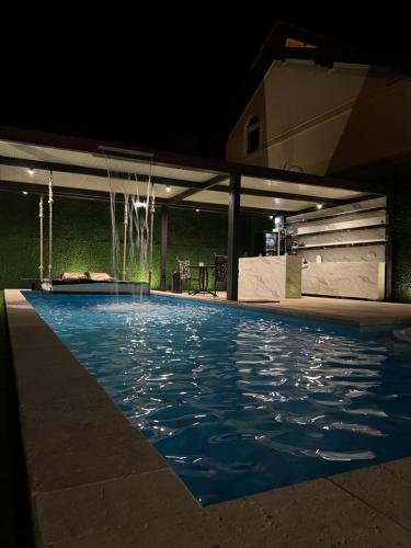 a swimming pool at night with a fountain at Spa Lux Apatin in Apatin