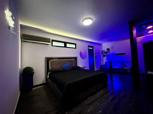 - une chambre avec un lit dans une chambre violette dans l'établissement Pasavento - Family Modern Suite, à Aguadilla