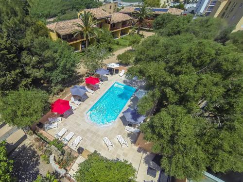 - une vue sur la piscine bordée de parasols et de chaises dans l'établissement Casa Vecchia rooms + apartments, à Calvi