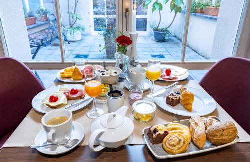 een tafel met borden ontbijtproducten en koffie bij Batschari Palais Baden-Baden in Baden-Baden