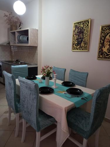 a dining room table with blue chairs and a table and chairsktop at Panoramic apartment in Shkodër