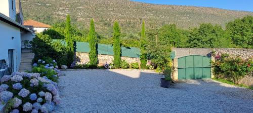 um jardim com um portão verde e um edifício em Parreirais dos Moquinhos em Minde